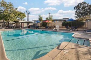 Una piscina al aire libre, sillones reclinables de piscina