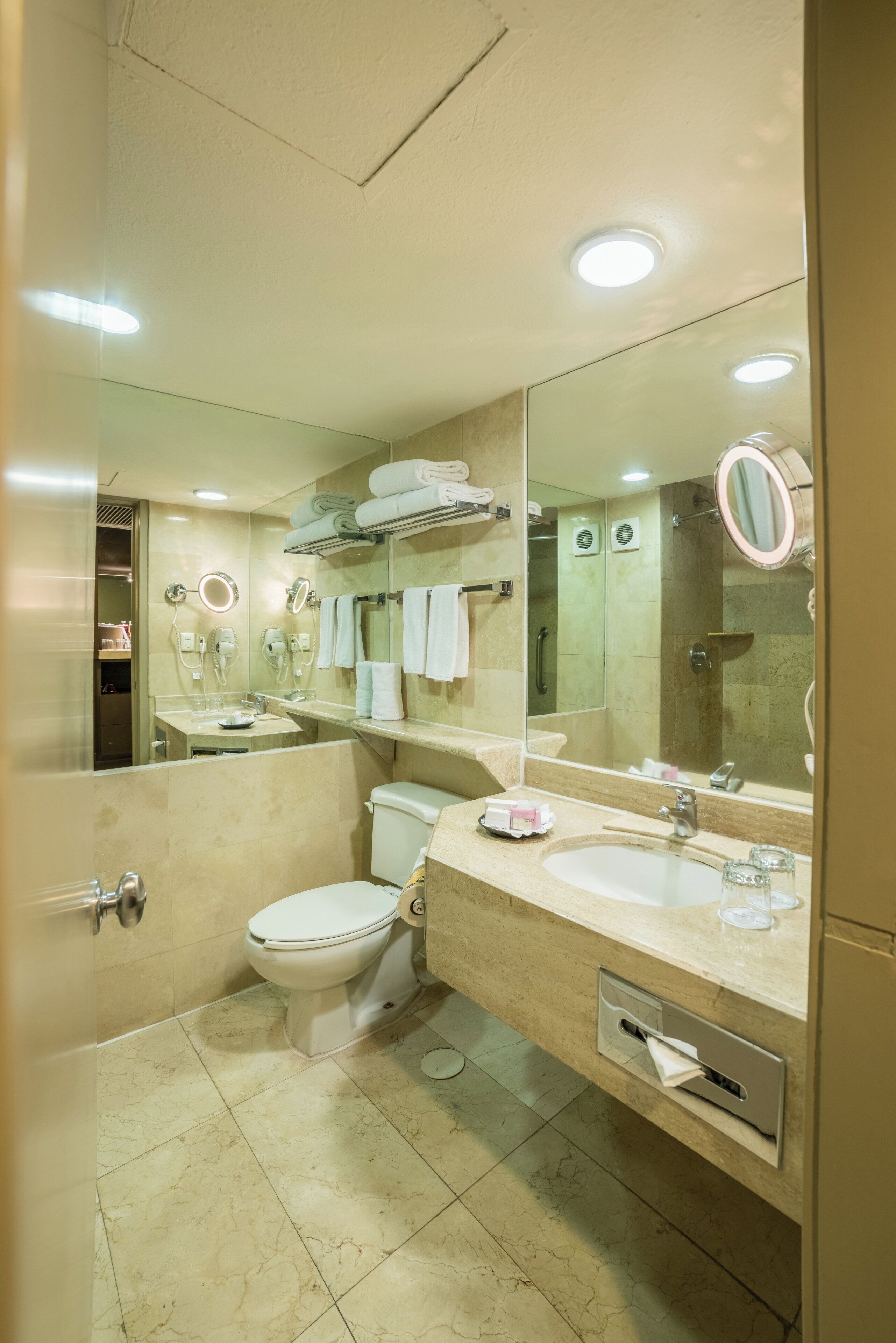 A modern bathroom with a toilet, sink, and mirror.