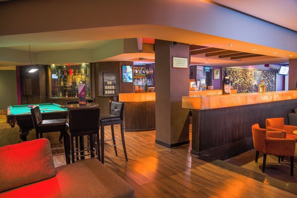 A bar area with a pool table, bar stools, and a bar counter. - Holiday Inn Guadalajara Expo by IHG (Zapopan)