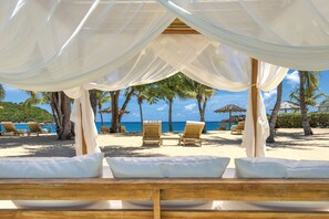 On the beach, white sand, sun loungers, beach umbrellas