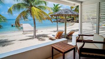 Na praia, areia branca, espreguiçadeiras, guarda-sóis