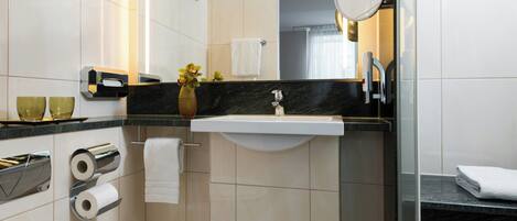 A modern bathroom with a toilet, sink, and mirror.