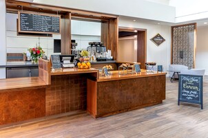 Mostrador de cafetería con una pizarra de menú, una máquina de café y un letrero que dice 
