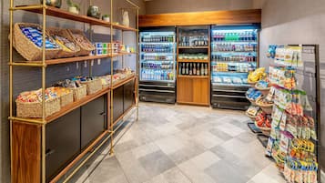 Un supermercado con estantes repletos de bocadillos, bebidas y productos envasados.