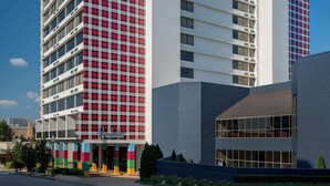 Un hôtel dont la façade est ornée d’un motif à carreaux rouges et blancs, et sur lequel on peut lire l’inscription « Graduate ».