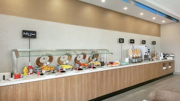 Un mostrador de buffet con diversos alimentos y salsas.
