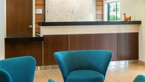 A reception area with a wooden door labeled "OFFICE," a black counter, and two blue chairs. - Fairfield Inn & Suites by Marriott Springfield (Springfield)