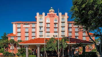 A hotel with a red facade, multiple balconies, and a sign reading "Sheraton Suites".