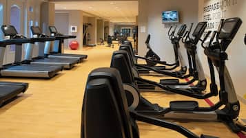 A gym with treadmills, ellipticals, and exercise balls.