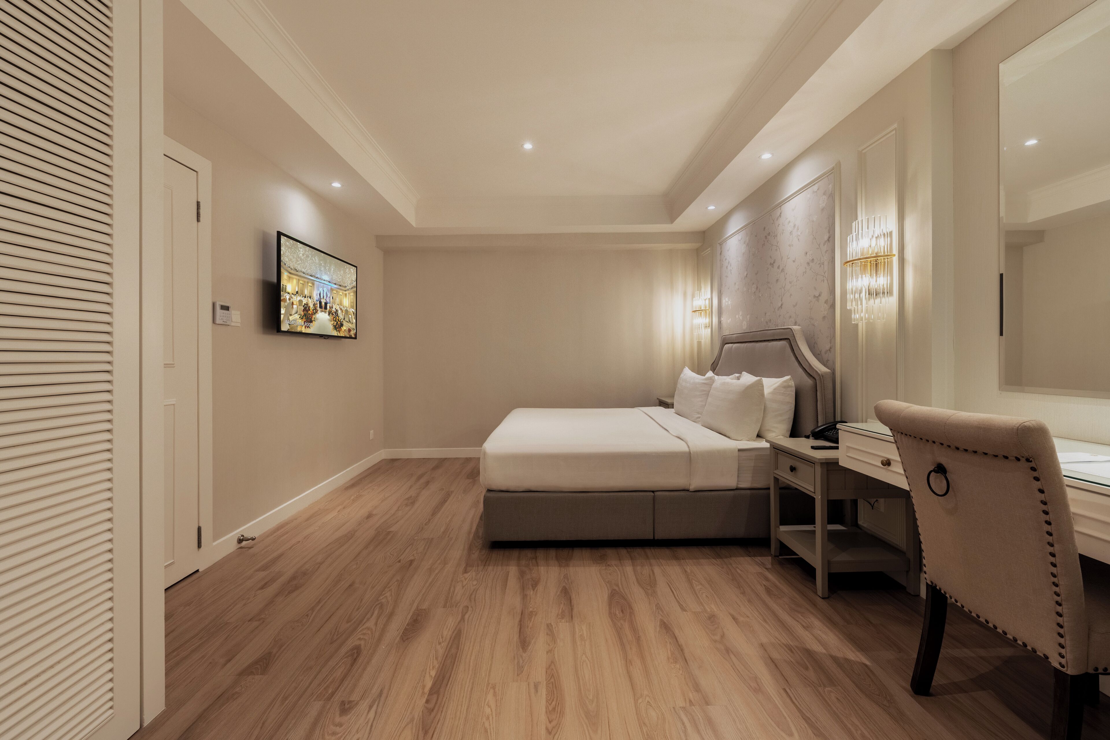 A bedroom with a bed, a desk, and a chair.