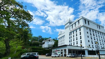 El Hotel PALACE con fachada blanca, varios pisos y una entrada destacada.