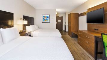 A hotel room with two beds, a desk, a TV, and a wardrobe.