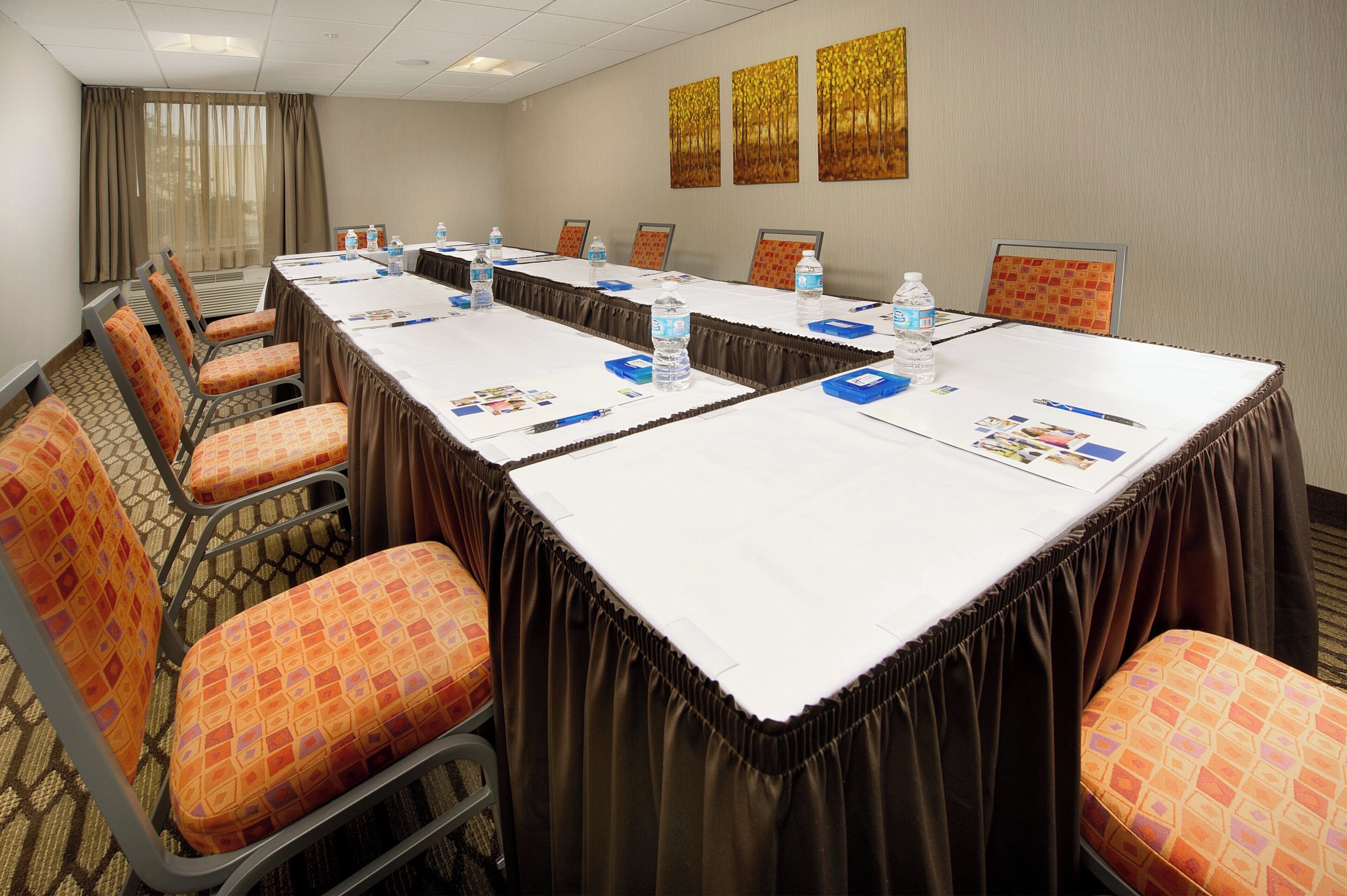 A conference room with a long table, chairs, and water bottles.