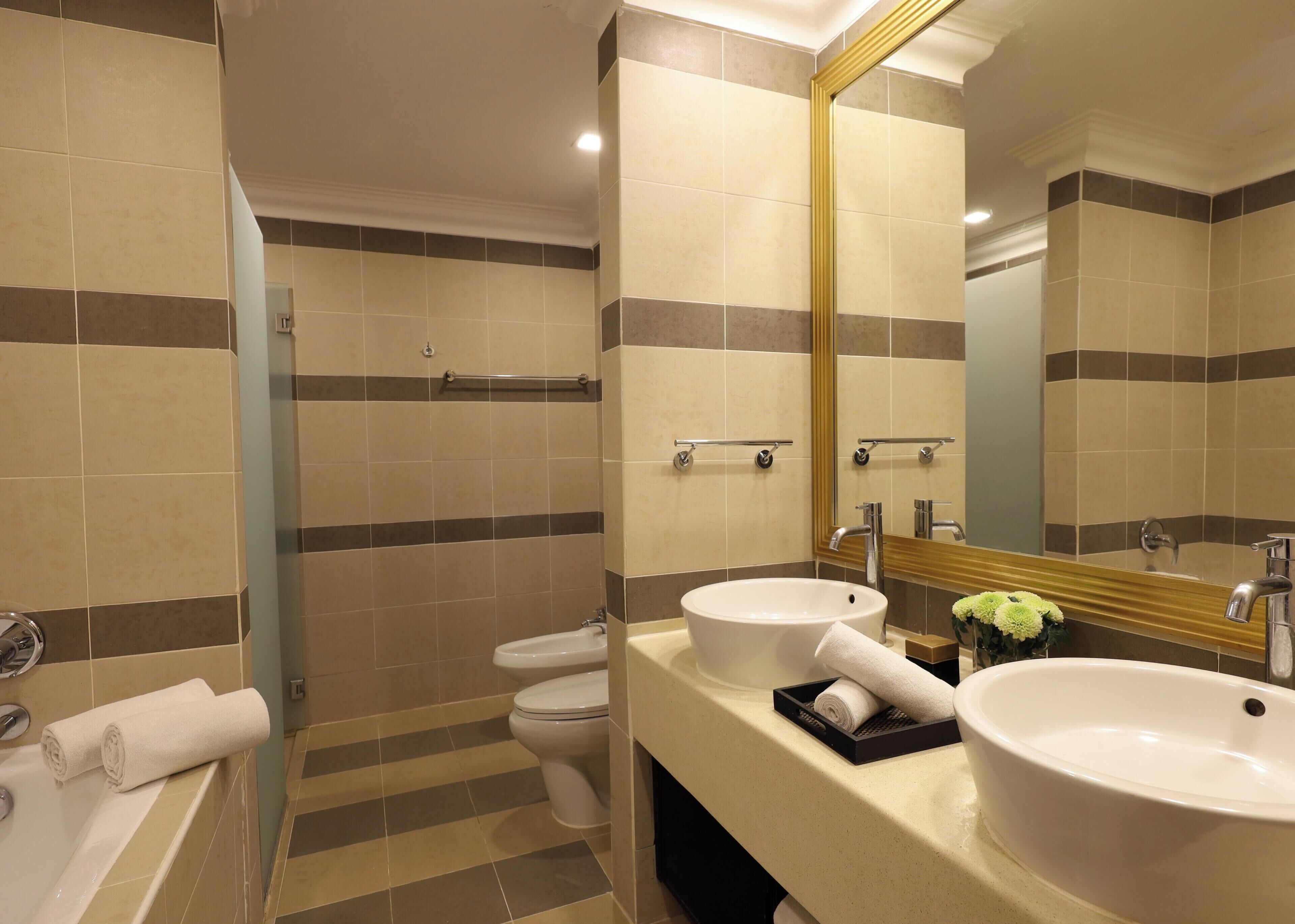 Ein modernes Badezimmer mit zwei Waschbecken, einer Toilette und einer Badewanne.