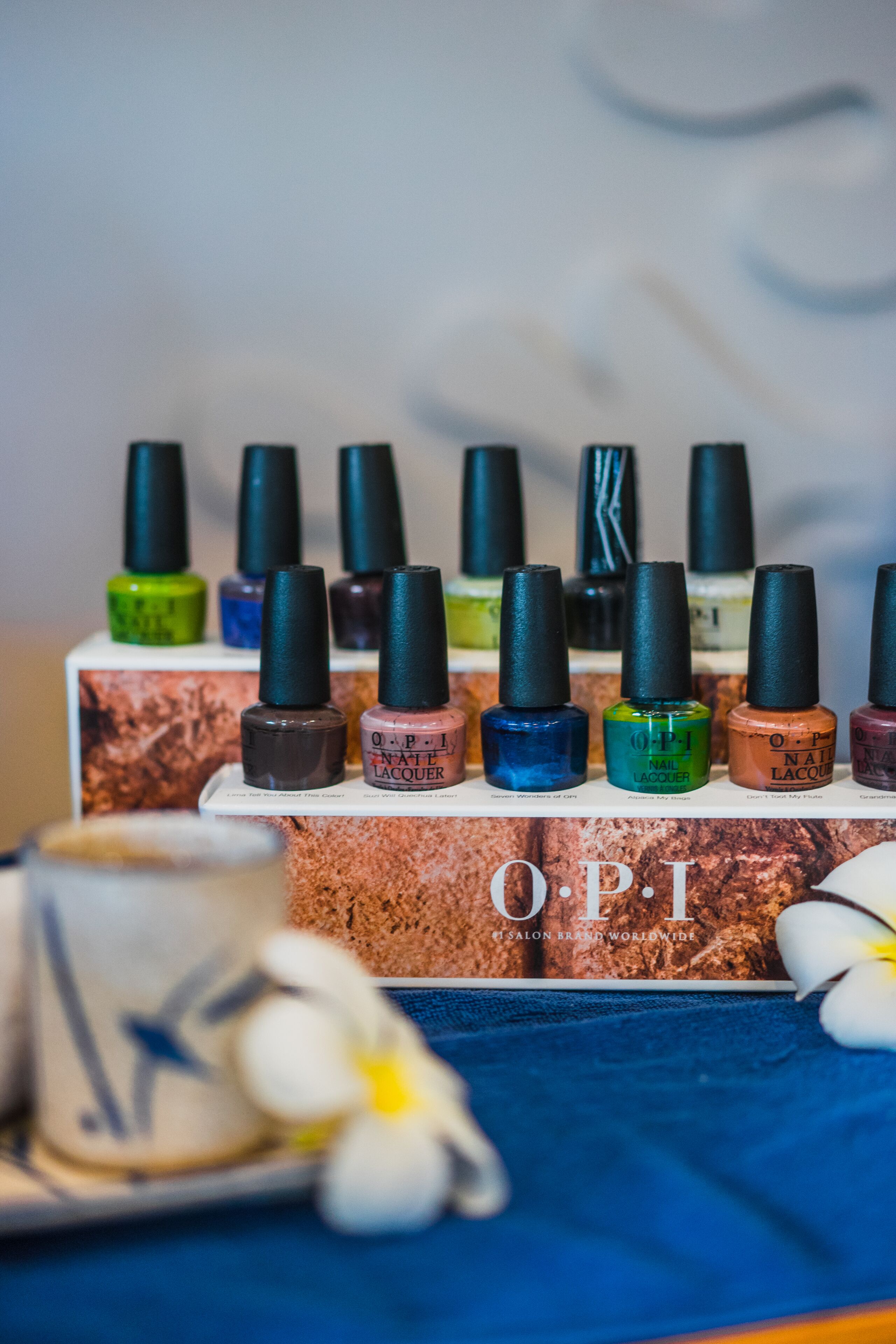 A display of OPI nail polish bottles on a box with a floral design.