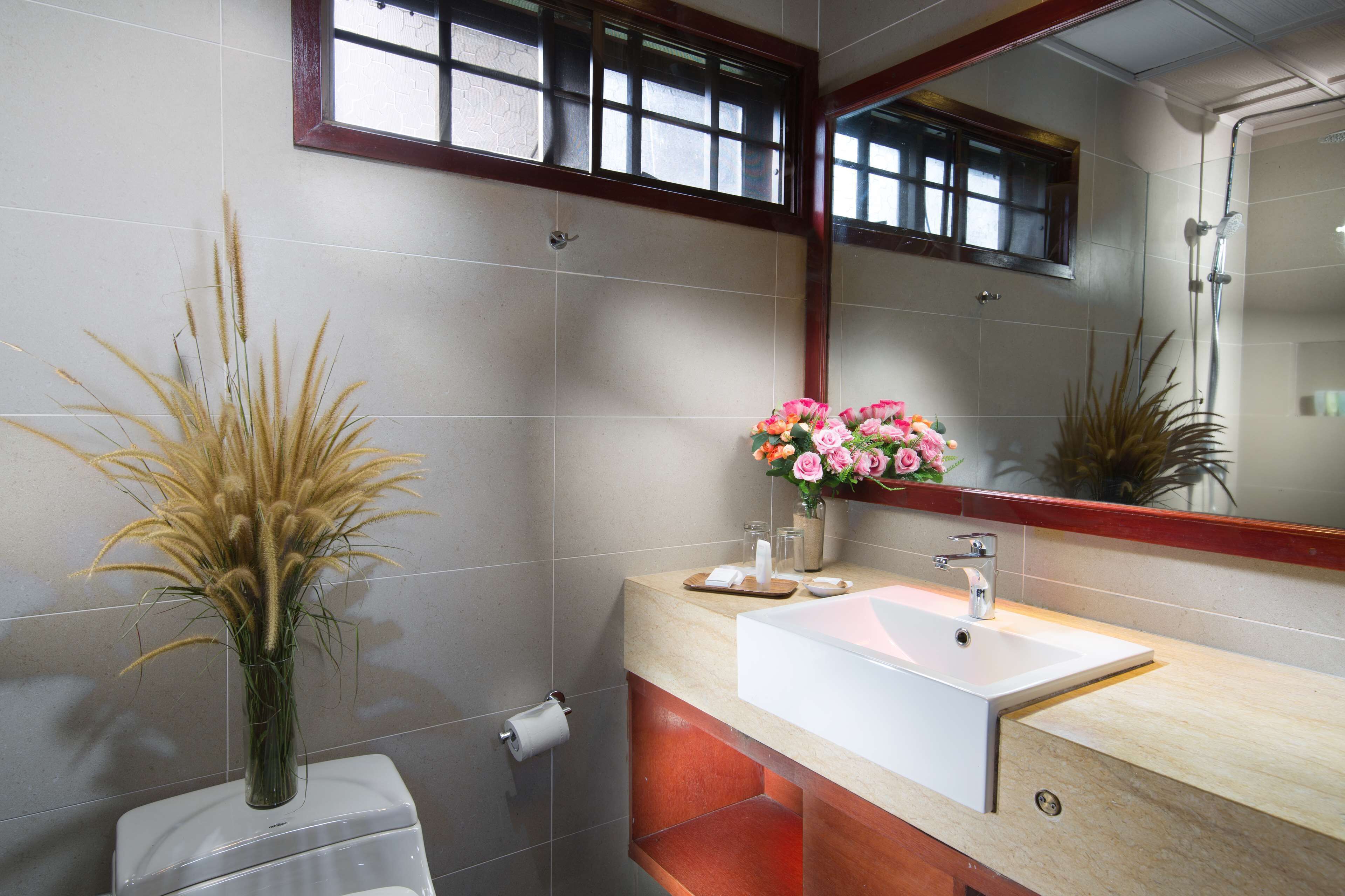 A bathroom with a white sink, a mirror, and a toilet.