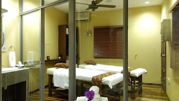 Relax in a serene space with a large bathtub, double bed, and comfortable seating area.