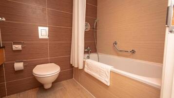 Un baño con inodoro, bañera y ducha.