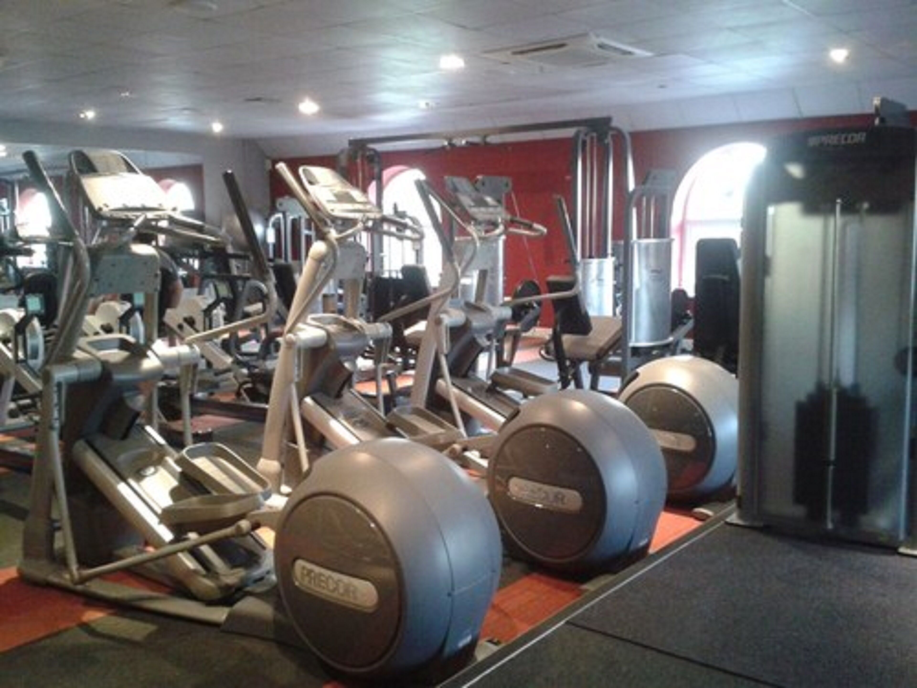 A gym with exercise equipment, including treadmills and elliptical machines.