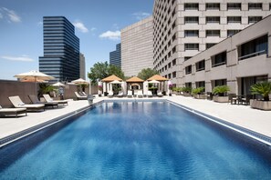 Una piscina al aire libre, tumbonas