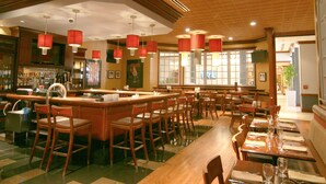 Ein Restaurant mit Bar, mehreren Tischen und Stühlen.