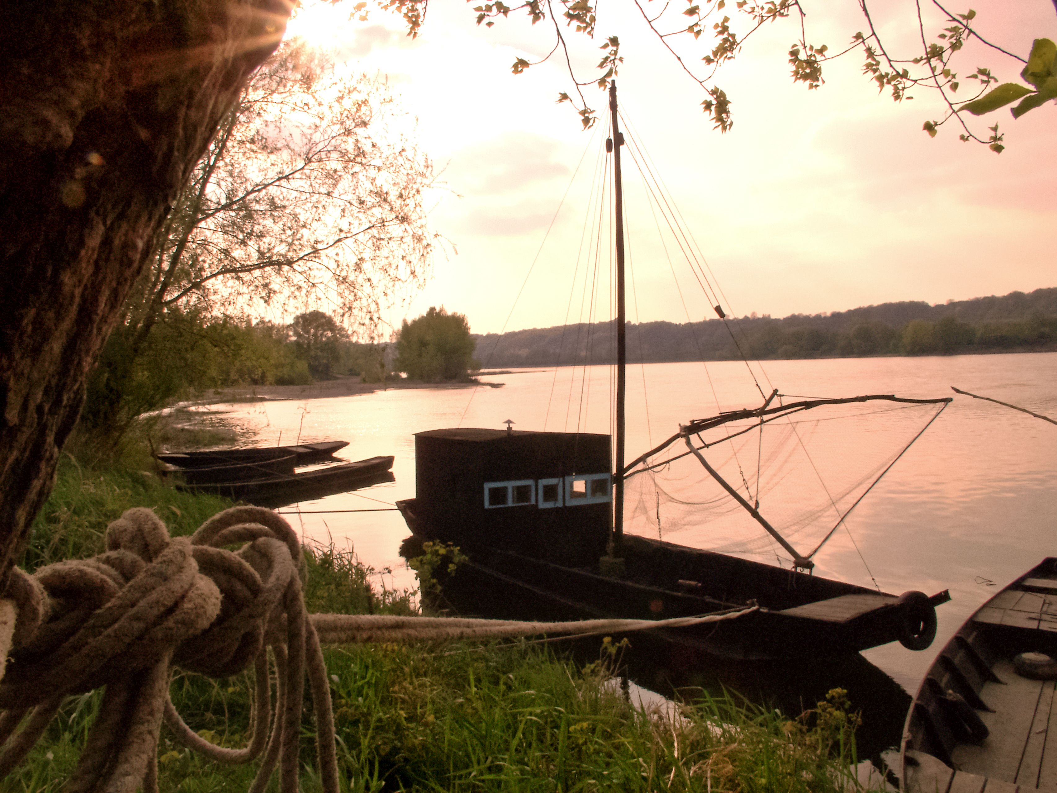 A dock with boats, a rope, and a building with a window.
