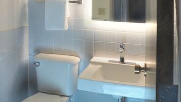Un baño moderno con inodoro, lavabo y espejo.