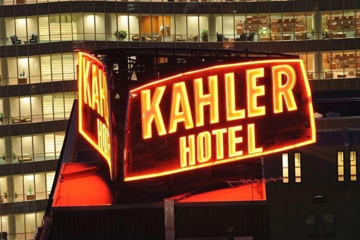 Un letrero de hotel con el nombre 'Kahler Hotel' en brillantes luces de neón.