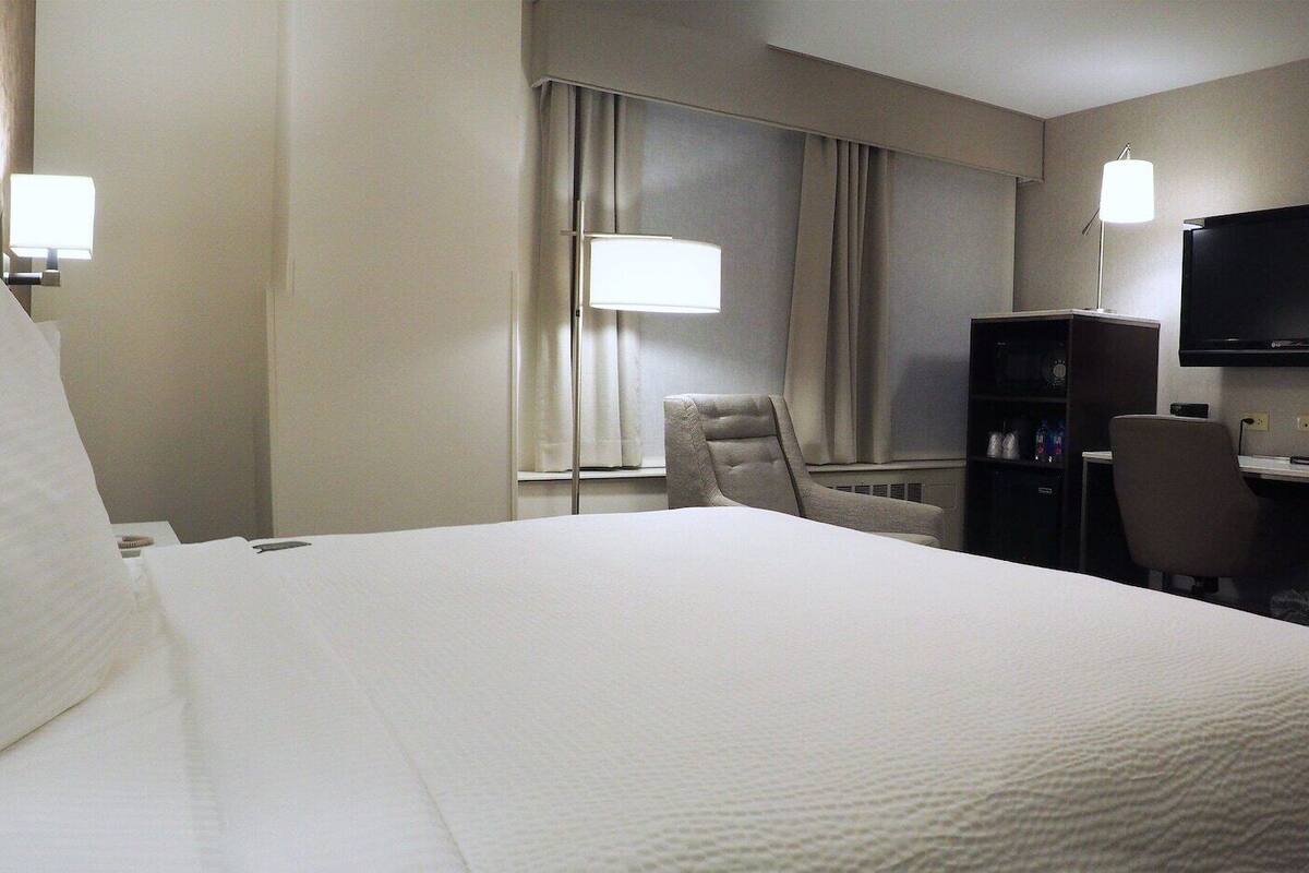 Premium bedding, desk, laptop workspace, blackout drapes