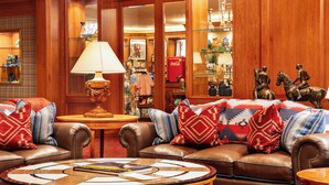 A cozy lobby with leather sofas, a round coffee table, and a wooden floor. - Little America Cheyenne (Cheyenne)