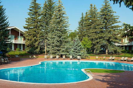 Una piscina al aire libre de temporada, sillones reclinables de piscina