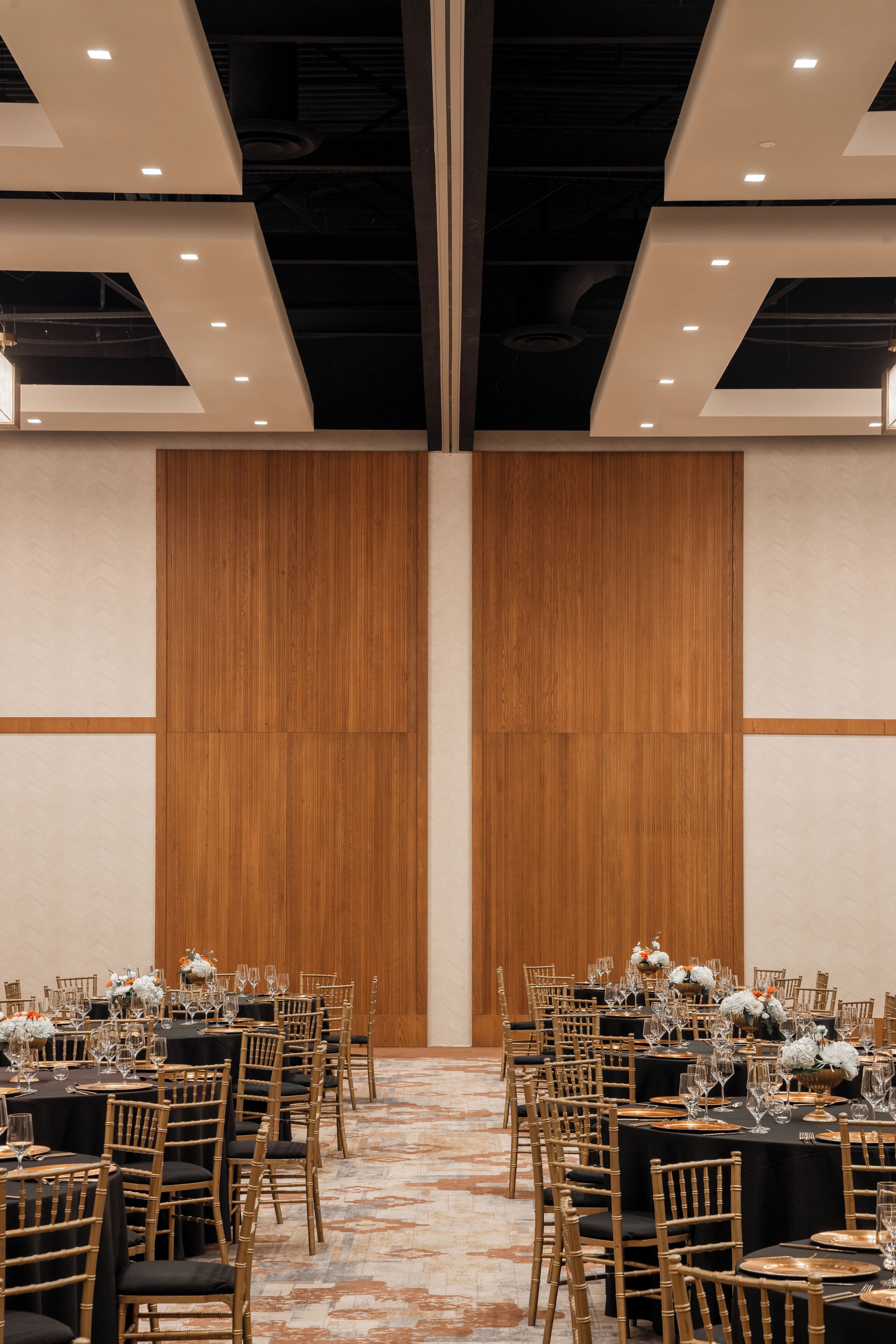 Un salón de conferencias con mesas dispuestas para una reunión, equipado con sillas y mesas.