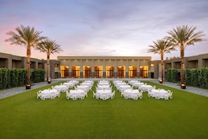 A hotel courtyard with multiple round tables arranged on a lawn, surrounded by palm trees and hedges. - DoubleTree Resort by Hilton Paradise Valley - Scottsdale (Scottsdale)