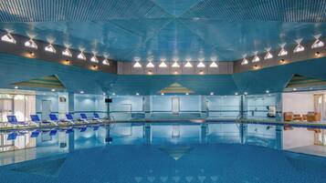 Una piscina cubierta, tumbonas