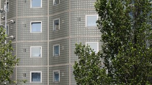 Un edificio de hotel de diseño moderno, con un llamativo letrero de 'ibis HOTEL' en el techo.