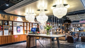 Un interior moderno con paneles de madera, un mostrador de recepción y una zona de bar.