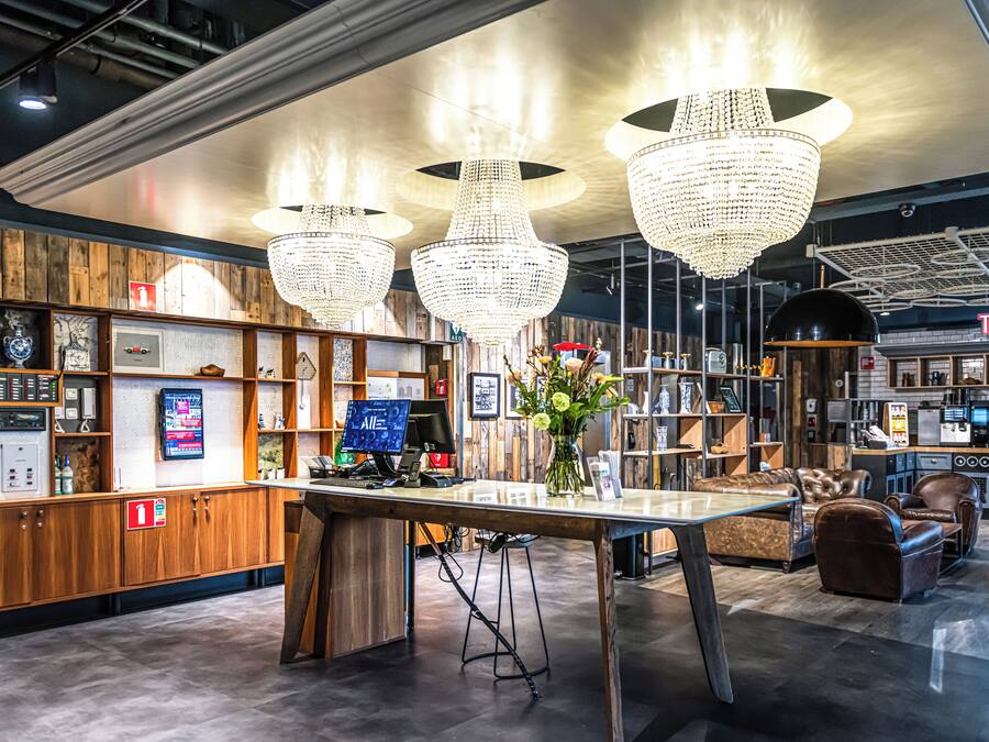 Un interior moderno con paneles de madera, un mostrador de recepción y una zona de bar.
