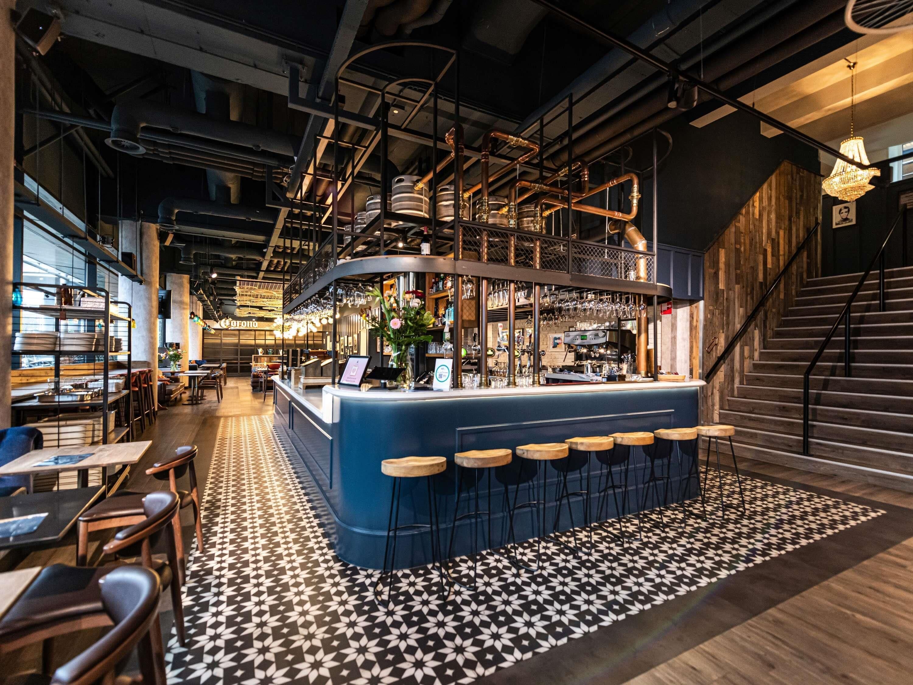 A bar area with stools, a counter, and a patterned floor.
