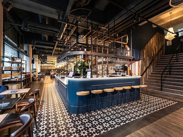 A bar area with stools, a counter, and a patterned floor. - ibis Amsterdam Centre (Amsterdam)