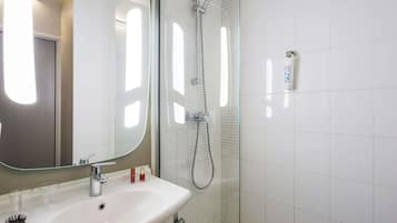 Ein Badezimmer mit Waschbecken, Spiegel und Dusche.