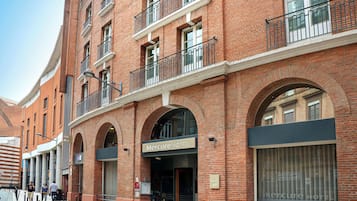 Experience the classic charm of Mercure Hotel, featuring arched windows and balconies with black railings.