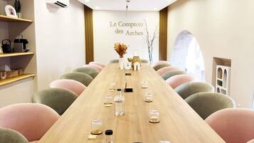 Un salón de conferencias con una larga mesa, sillas y un letrero que dice 'Le Comptoir des Arches'.