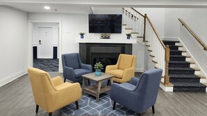 Una sala de estar moderna con chimenea, televisor y escalera.
