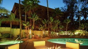 A poolside area with a fire pit, lounge chairs, and a pool.