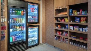 A vending machine area with multiple beverage dispensers and snack shelves.