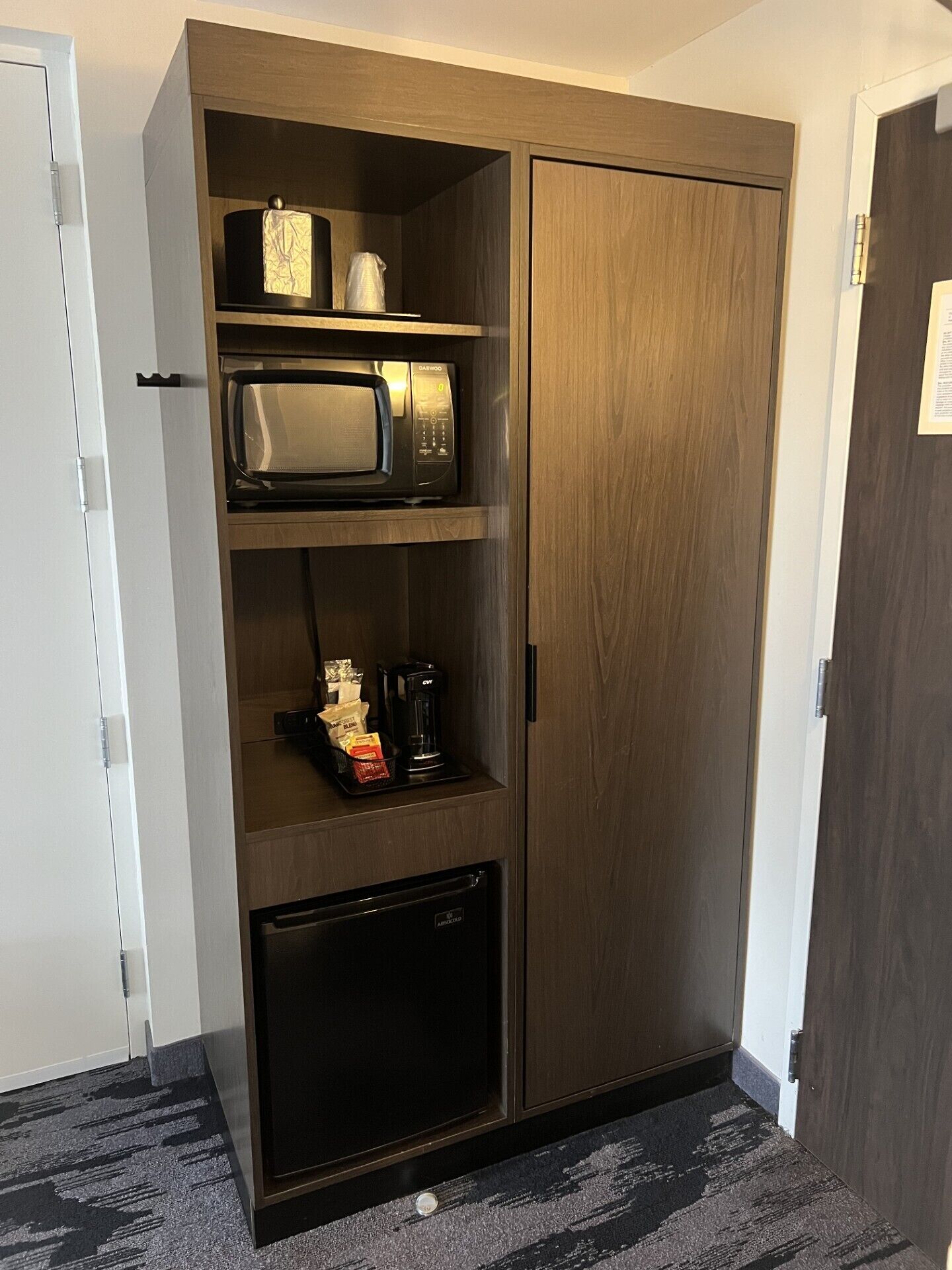 Un armario con microondas, cafetera y un refrigerador pequeño.