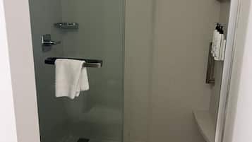 Une salle de bain moderne avec une douche à parois de verre, des toilettes et un porte-serviettes.