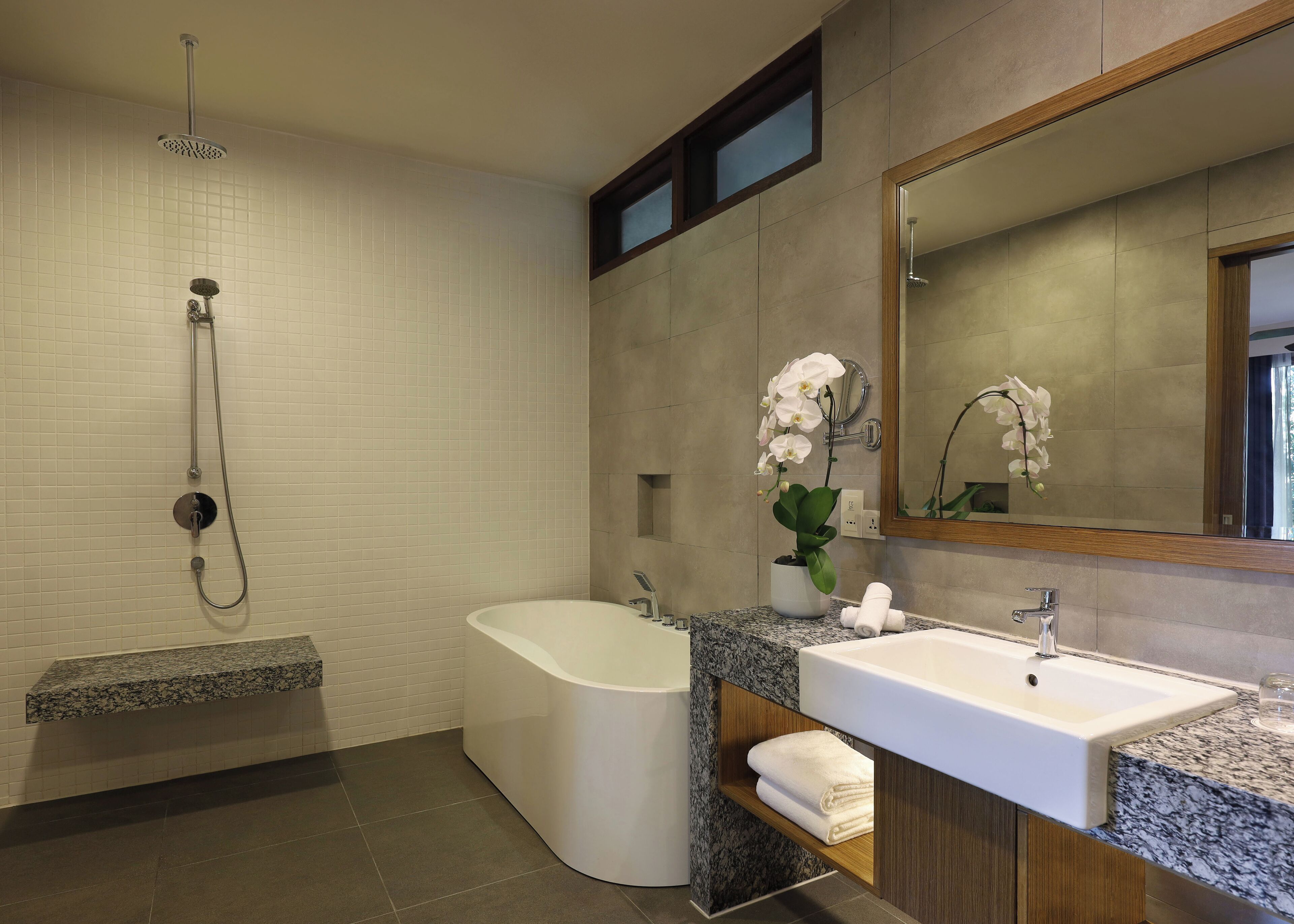 Une salle de bain moderne avec une baignoire sur pieds, un lavabo et une douche.