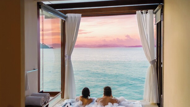 A couple relaxing in a hot tub with a view of the ocean and a sunset. - Berjaya Langkawi Resort (Langkawi)