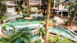 A pool area with a circular design, surrounded by lush greenery and stone pathways. - Berjaya Langkawi Resort (Langkawi)